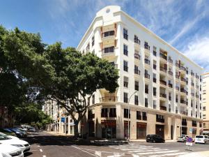 a large white building with a tree in front of it at Siena Urban Live Canarias in Santa Cruz de Tenerife