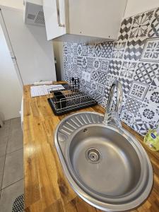 a stainless steel sink in a kitchen with tiles at Casita Hendaya - Agréable et cosy avec parking et WiFi in Hendaye
