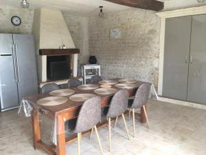 una cucina con tavolo con sedie e frigorifero di Gites Le Cheval Noir a Rouillac