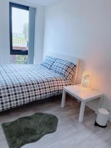 1 dormitorio con cama, mesa y ventana en Modern House, en Mánchester