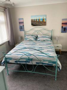 a bedroom with a bed with a blue metal frame at Hot Tub Beach Bungalow - free parking & child friendly in South Hayling