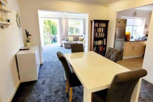 a kitchen and living room with a table and chairs at Hot Tub Beach Bungalow - free parking & child friendly in South Hayling