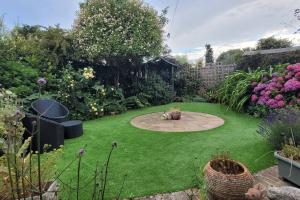 a small garden with a circularificialificialificialificialificialificialificialificialificial yard at Hot Tub Beach Bungalow - free parking & child friendly in South Hayling