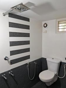 a bathroom with a toilet and black and white stripes at Mi Casa Tu Casa Homestay in Cochin