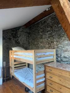 a bedroom with two bunk beds and a stone wall at Maison Centrale in Ax-les-Thermes