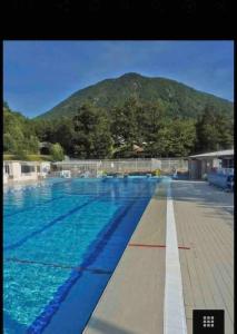 a large swimming pool with a mountain in the background at Maison Centrale in Ax-les-Thermes