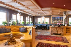 un ristorante con divano e tavolo di Hotel Somont a Selva di Val Gardena