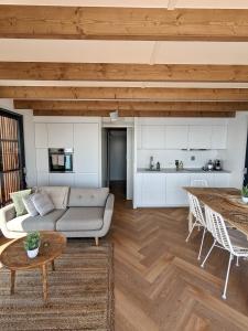 uma sala de estar com um sofá e uma mesa em Luxury Houseboat Liberdade with sauna and dinghy em Monnickendam
