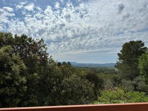 a view of trees and a sky with clouds at Les Cigales in Villelaure