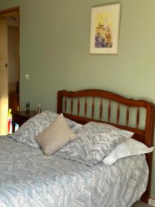 uma cama com almofadas e uma fotografia na parede em Les Cigales em Villelaure