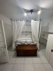 een kleine slaapkamer met een bed met een gordijn bij Sciabbacco house in Napels