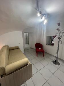 een woonkamer met een bank en een rode stoel bij Sciabbacco house in Napels