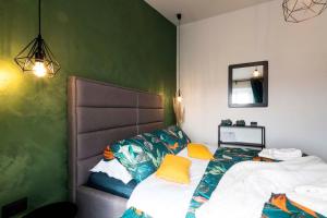 Un dormitorio con una cama y una pared verde. en Apartman Smaragd, en Fažana