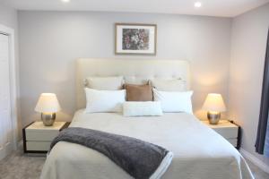 ein Schlafzimmer mit einem großen weißen Bett mit zwei Lampen in der Unterkunft Stylish Home For A Perfect Stay for 4! in Peterborough