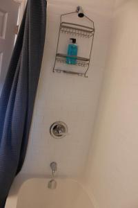 eine Badewanne mit einem Duschvorhang und einem Seifenspender in der Unterkunft Stylish Home For A Perfect Stay for 4! in Peterborough