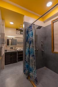 un bagno con doccia con tenda da doccia di Mangalmayee Heritage Home - Boutique Homestay a Jaipur