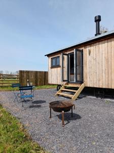 une petite maison avec une table et un banc dans l'établissement Old Quay Escape, à Tenby