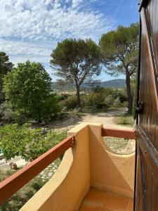 einen Balkon mit Blick auf ein Feld und Bäume in der Unterkunft Les Cigales in Villelaure