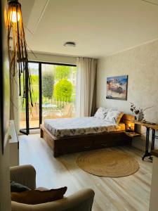 een slaapkamer met een groot bed en een groot raam bij Relax studio in Sozopol