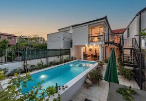 a swimming pool in the backyard of a house at Villa Jelić ZadarVillas in Nin