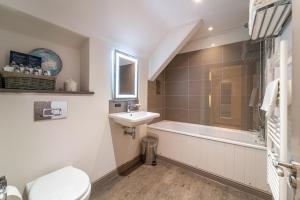 a bathroom with a sink and a tub and a toilet at Plas Weunydd in Blaenau-Ffestiniog