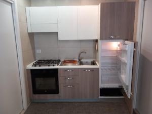 een kleine keuken met een open koelkast en een fornuis bij Il faletto in Trani