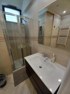 een badkamer met een witte wastafel en een douche bij Il faletto in Trani