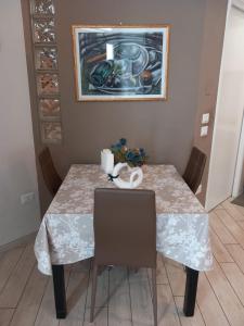 een eettafel met 2 stoelen en een schilderij bij Il faletto in Trani