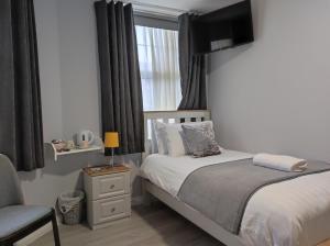 a small bedroom with a bed and a window at Kingdom Lodge in Killarney