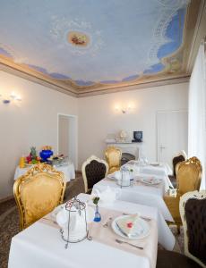 un comedor con mesas blancas y sillas amarillas en Boutique Hotel Villa Sarnia, en San Nazzaro