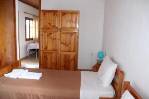 - une chambre avec un lit et une armoire en bois dans l'établissement Seaside 1, à Kómboi
