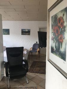 a room with a chair and a painting on the wall at Ferienwohnung Nett in Adenau