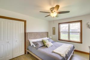 um quarto com uma cama e uma ventoinha de tecto em La Petit Maison - Lakefront Oshkosh Home! em Oshkosh