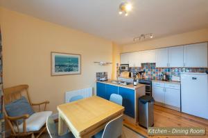 a kitchen with a wooden table and a kitchen dining room at Puffling Cottage in North Berwick