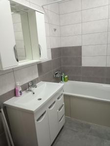 a bathroom with a sink and a tub and a mirror at Apartment COMFORT on Ruska street in Chernivtsi
