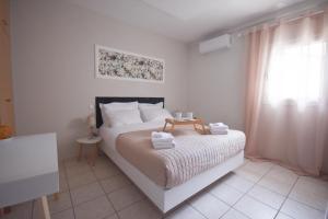 a bedroom with a bed with towels on it at K&C Rooms- Apartments in Markopoulo