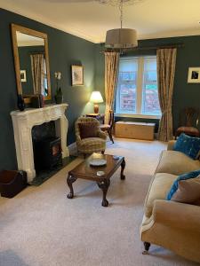 a living room with a couch and a coffee table at Luxury Garden Cottage in Dalry