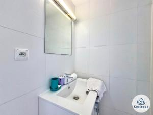 ein weißes Badezimmer mit einem Waschbecken und einem Spiegel in der Unterkunft Anjou 1 - studio de 20 m2 à Saint-Denis in Saint-Denis