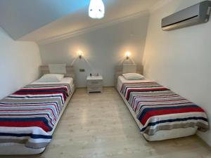 two beds in a small room with two at AKBÜK Palace Resıdence in Didim