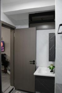 a bathroom with a door leading to a sink at Lux Suites Royal Gardens Studio Apartments in Nairobi