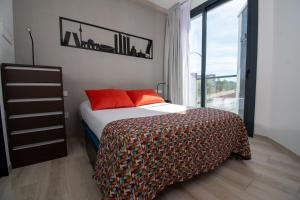 a bedroom with a bed with orange pillows and a window at Ekilibrio Hotel & Apart-Suites in Madrid