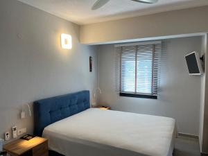 una camera da letto con letto con testiera blu e finestra di Nikiti Heart Luxury Villa a Nikiti