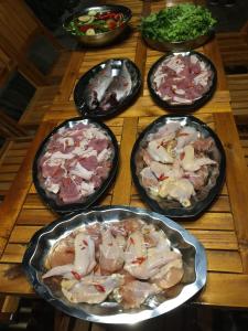 a wooden table topped with four different types of pizzas at Tuyết Hoa Hòn Bồ Homestay in Da Lat