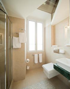 a bathroom with a sink and a toilet and a window at Boutique Hotel Villa Sarnia in San Nazzaro