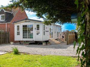 ein weißes Haus mit einer Veranda und einem Zaun in der Unterkunft Birchwood in Skegness in Skegness