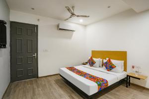 1 dormitorio con 1 cama grande y puerta negra en FabHotel VAT - Meera Bagh, en Nueva Delhi