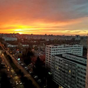 a view of a city at sunset from a building at Perfect View Apartament in Bucharest