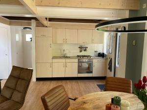 a kitchen with white cabinets and a table and chairs at Zandrijk in Egmond aan den Hoef