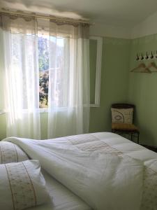 a bedroom with a large white bed and a window at La Parenthèse in Tautavel