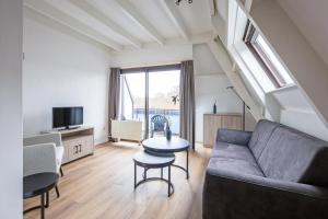 een woonkamer met een bank en een tafel bij Appartementen Beatrix in De Koog